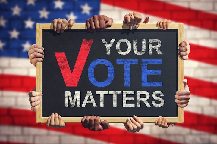 A lot of hand are holding a banner with text YOUR VOTE MATTERS on background of American flag. Your Vote Matters. Concept of voter rights and US election.